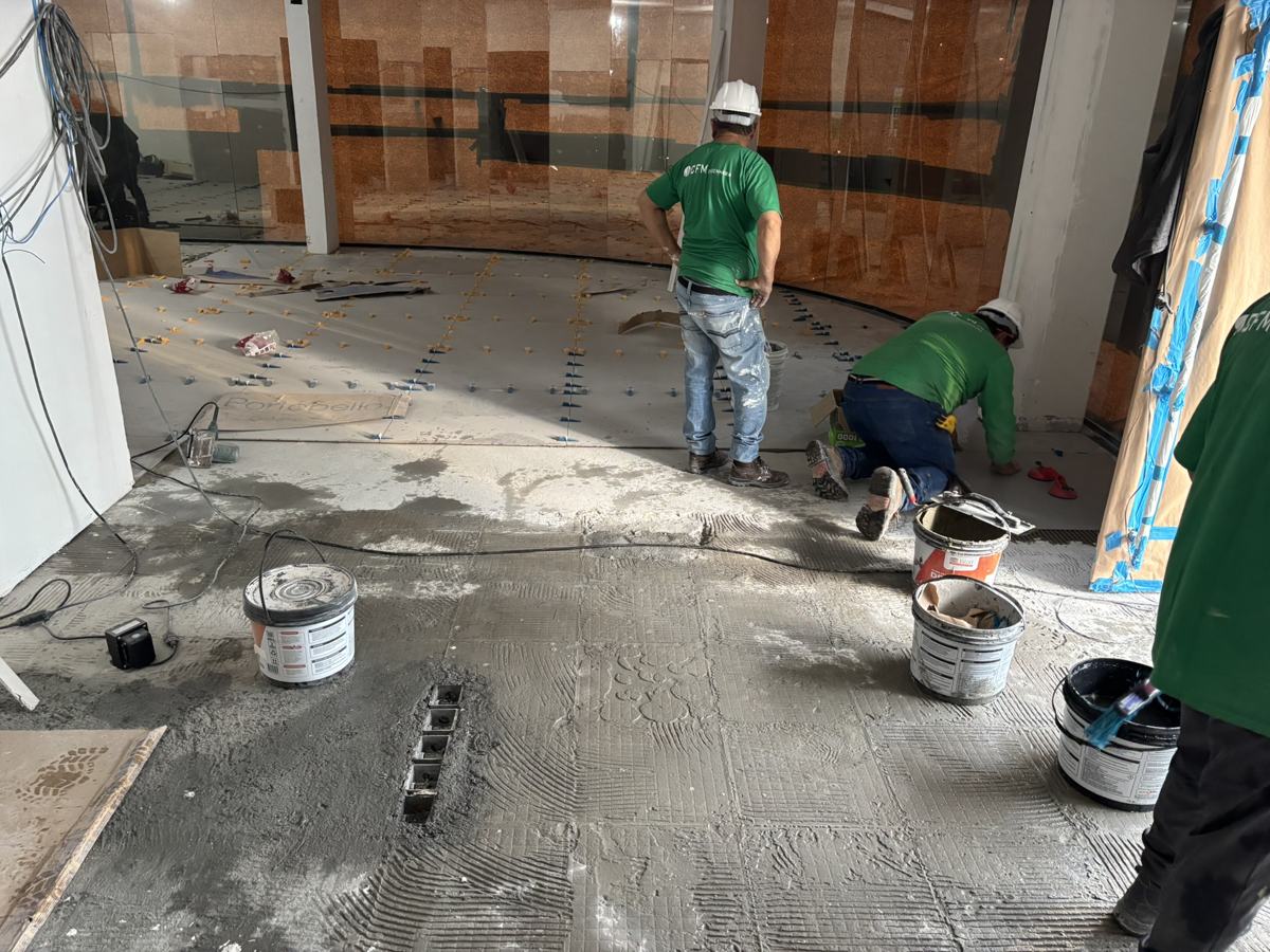 Equipe aplicando revestimento de piso em obra