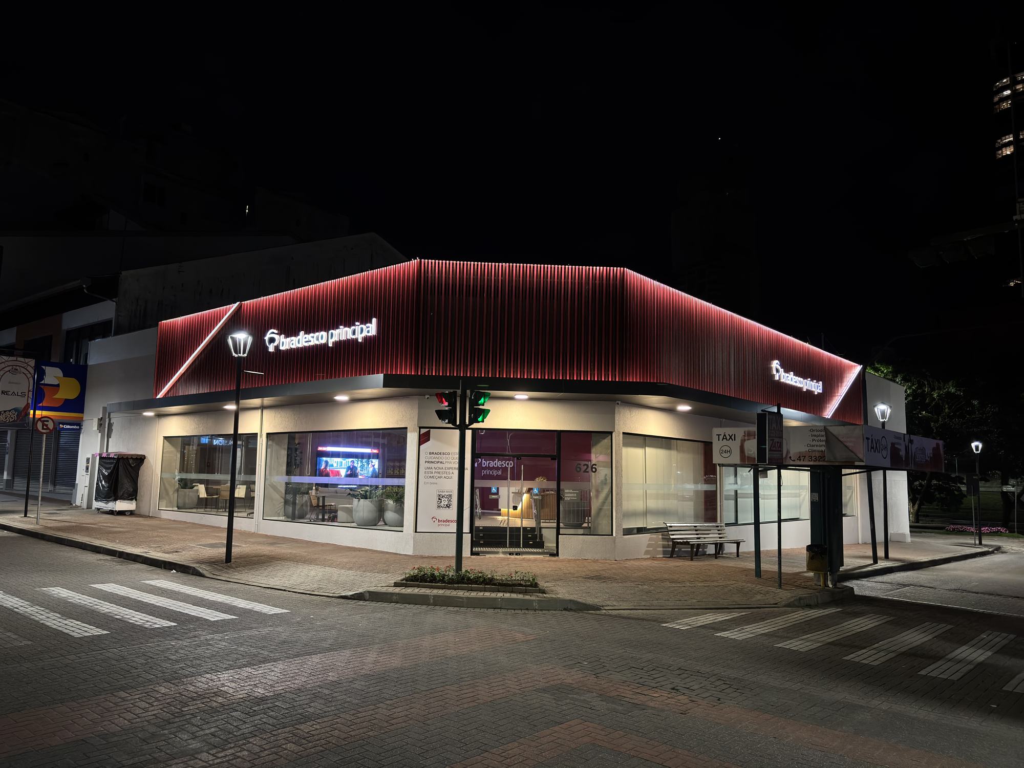 Fachada noturna de esquina da agência Bradesco Principal em Blumenau