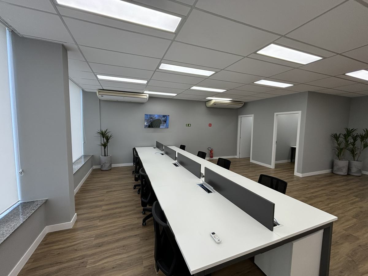 Escritório corporativo com estações de trabalho, piso vinílico e forro modular